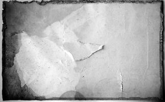 A grayscale aged paper texture with torn edges, creases, and stains, perfect for vintage design projects. photo