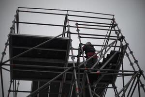 Workers on scaffolding. Construction of the structure. Installers in the process of work. photo