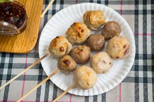 Three skewers grilled of meatballs include porkball, squidball and beefball on skewers photo