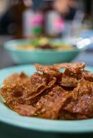Sliced sheets of dried and crispy pork on dish. photo