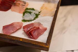 Fresh set of raw sashimi fish on wooden board background photo