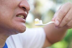 Close up man holds toothbrush with toothpaste. Concept, dental health care. Brush teeth with fluoride toothpaste for hygiene, clean and strong teeth. Prevention from tooth decay. photo