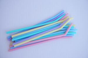 Colorful plastic drinking straws tubes for juice and cocktails. Concept, single use equipment for drinking, but can use for DIY. crafts for decoration. photo
