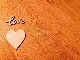 A sweet romantic heart with the word Love lies on a rustic wooden surface. photo