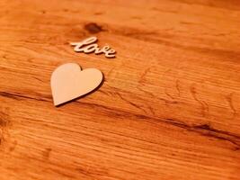A sweet romantic heart with the word Love lies on a rustic wooden surface. photo