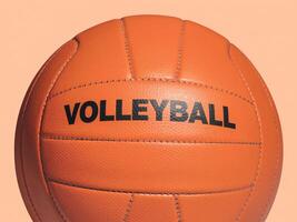 Close-up of an orange volleyball with bold black text against a soft peach background. photo