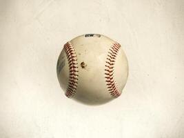A close-up of a well-worn baseball with visible stitching and dirt marks. photo