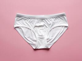 White cotton briefs on a soft pink background, showcasing simplicity and comfort. photo