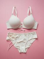Stylish white lingerie set on a soft pink background, featuring modern design and delicate details. photo