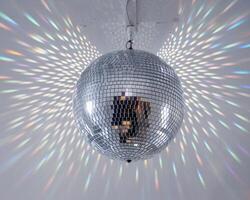 A sparkling disco ball reflecting vibrant light patterns in a lively atmosphere. photo
