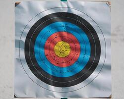 A close-up of a colorful archery target with vibrant blue, red, yellow, and black concentric circles. photo