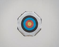 An archery target featuring vibrant colors in a circular pattern, depicting various scoring zones. photo
