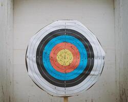 A colorful archery target displaying multiple scoring zones, with visible wear and marks. photo