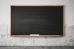 Empty chalkboard in a classroom setting with a rustic wall background. photo