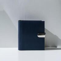 Stylish navy blue binder with sleek metallic clasp, set against a minimalist background. photo