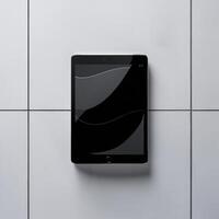 A sleek, modern tablet lies on a minimalist tiled surface, showcasing its elegant design. photo