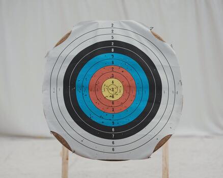 A close-up of a target with colorful concentric circles set against a neutral background. photo