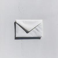 A white envelope rests against a soft gray background, casting a gentle shadow. photo