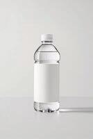 Clear plastic water bottle with a blank label, isolated against a soft gray background. photo