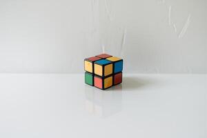A classic Rubik's Cube on a clean, white surface, showcasing its vibrant colors and intricate design. photo