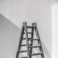 A rustic wooden ladder against a minimalist white wall, casting a soft shadow in a serene atmosphere. photo