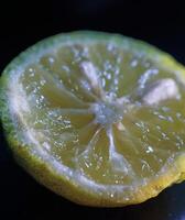 a close up of a lemon on a black surface photo