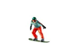 Miniature figurine depicting a snowboarder in mid-motion isolate on white background with clipping path photo