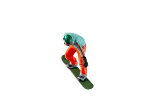 Miniature figurine depicting a snowboarder in mid-motion isolate on white background with clipping path photo