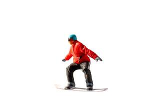 Miniature figurine depicting a snowboarder in mid-motion isolate on white background with clipping path photo