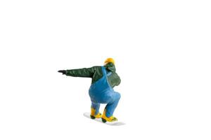 Miniature figurine depicting a snowboarder in mid-motion isolate on white background with clipping path photo