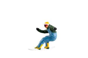 Miniature figurine depicting a snowboarder in mid-motion isolate on white background with clipping path photo