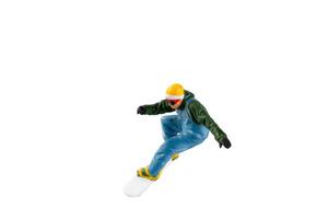 Miniature figurine depicting a snowboarder in mid-motion isolate on white background with clipping path photo