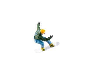 Miniature figurine depicting a snowboarder in mid-motion isolate on white background with clipping path photo