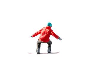 Miniature figurine depicting a snowboarder in mid-motion isolate on white background with clipping path photo