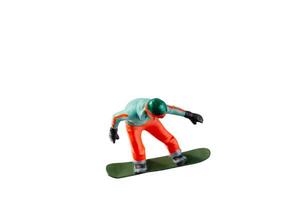 Miniature figurine depicting a snowboarder in mid-motion isolate on white background with clipping path photo