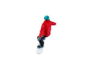 Miniature figurine depicting a snowboarder in mid-motion isolate on white background with clipping path photo