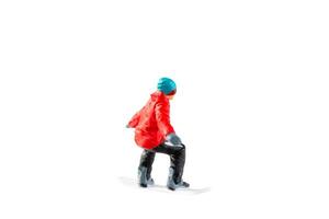 Miniature figurine depicting a snowboarder in mid-motion isolate on white background with clipping path photo