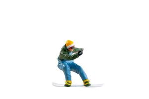 Miniature figurine depicting a snowboarder in mid-motion isolate on white background with clipping path photo