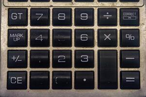 Close up of a vintage calculator keypad with various function keys photo