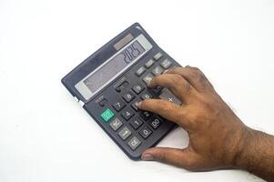 A hand pressing buttons on a large calculator displaying the number 2025. This image represents financial calculations, budgeting, or accounting tasks photo