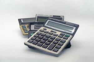 A pile of old calculators symbolizes inflation, representing outdated financial tools and the increasing cost of living photo