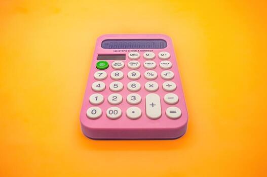 un brillante rosado calculadora con grande botones y un claro mostrar, conjunto en contra un vibrante amarillo antecedentes. Perfecto para escuela, oficina, o todos los días utilizar foto