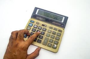 A close up of a hand pressing buttons on an old, dusty calculator displaying the number 2025. This image represents financial calculations or accounting work photo
