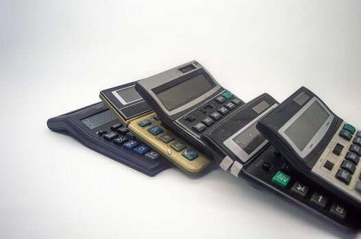 A pile of old calculators symbolizes inflation, representing outdated financial tools and the increasing cost of living photo