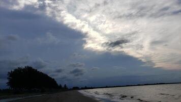 Cloudy Sky Over a Sandy Beach with Gentle Waves photo