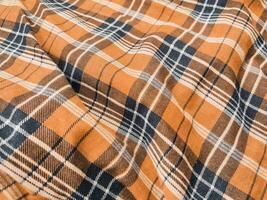 The pattern and background of the fabric has a orange checkered motif photo