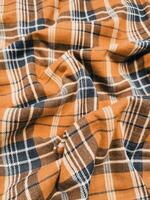 The pattern and background of the fabric has a orange checkered motif photo