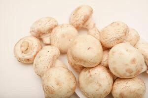 Fresh champignons on a white plate. Mushrooms on a white background. photo