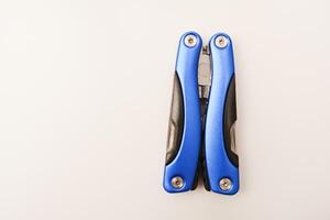 Multitool on a white background. Pocket multi-tool. Saw, knife and pliers. photo
