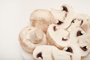 Fresh champignons on a white plate. Mushrooms on a white background. photo